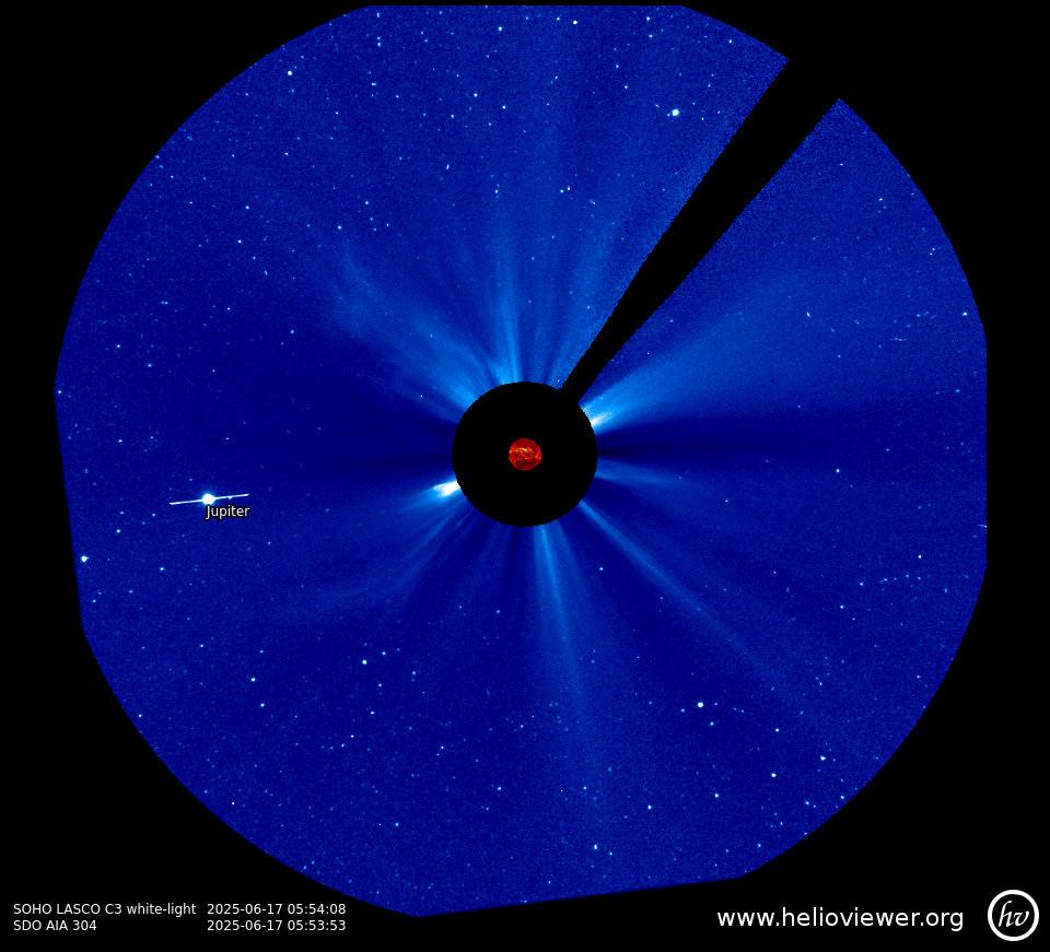 Imagem capturada pelo satélite SOHO (instrumento LASCO C3), mostrando o planeta Júpiter à esquerda do Sol, localizado no centro. O centro da imagem está coberto por um disco preto que oculta o Sol para destacar sua coroa. Sobre o disco preto, sobrepondo a imagem, há uma representação em vermelho do Sol em ultravioleta, observado pelo telescópio SDO. Ao redor, filamentos se espalham em azul intenso. A data da observação é 17 de junho de 2025, com horário registrado às 05:54
No canto inferior direito está escrito "www.helioviewer.org" e a logo do site HelioViewer.