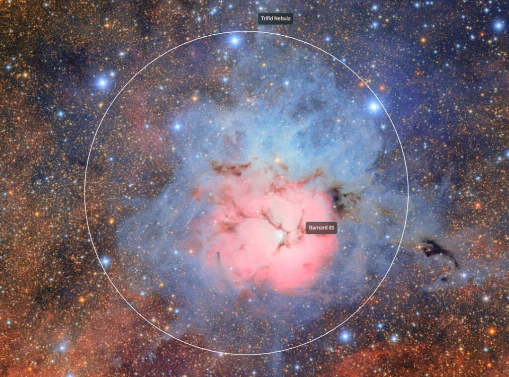 Imagem do Observatório Vera C. Rubin da Nebulosa de Trífida. A nebulosa apresenta região central rosada, cercada por uma área azulada. A nebulosa está envolta por um campo estelar denso, com muitas estrelas de fundo espalhadas em tons de azul e dourado.